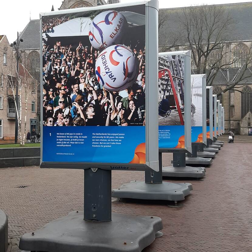 Mobiele billboards met foto’s over de NAVO achter elkaar opgesteld op kerkplein Alkmaar