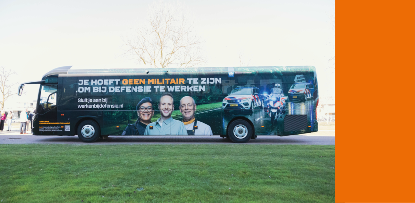 De nieuwe bus, zwart van kleur, met daarop de tekst: ‘Je hoeft geen militair te zijn om bij Defensie te werken. Sluit je aan bij werkenbijdefensie.nl.’