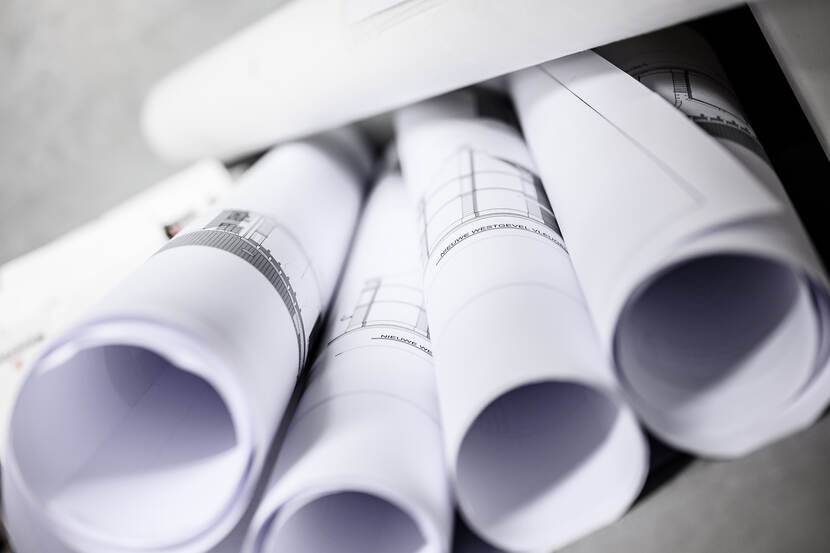 Rollen bouwtekeningen op een stapel