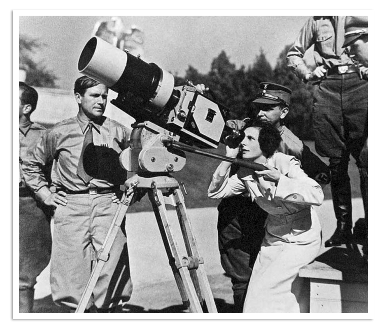 Leni Riefenstahl checkt het beeld en kijkt door de cameralens.