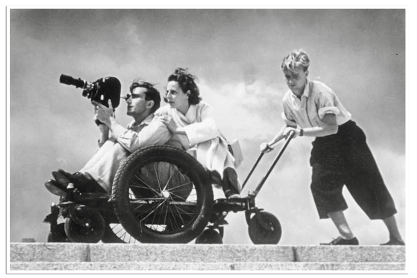 Een cameraman wordt voortgereden terwijl hij beelden maakt.