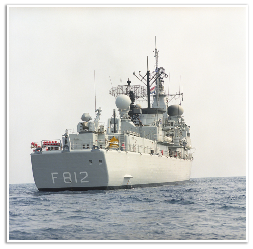 Een grijs marineschip op zee. Achterop staat in grote witte letters en cijfers ‘F 812’.