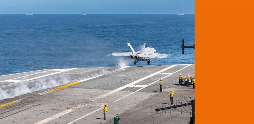 Een F/A-18 start vanaf een vliegdekschip op een rustige zee.