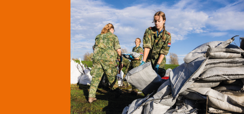 Militairen schouwen met zandzakken.