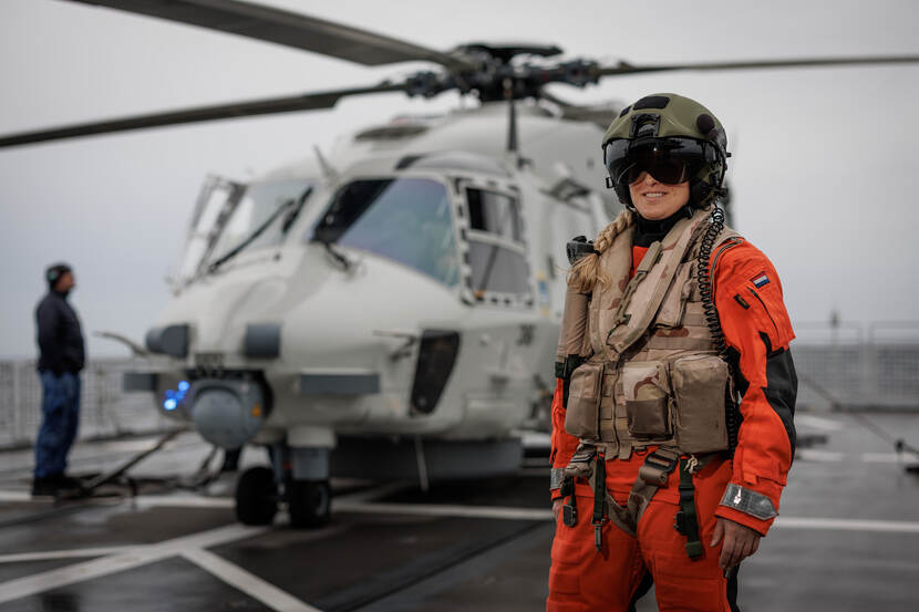 Portret van sergeant Jolien in oranje pak voor helikopter.
