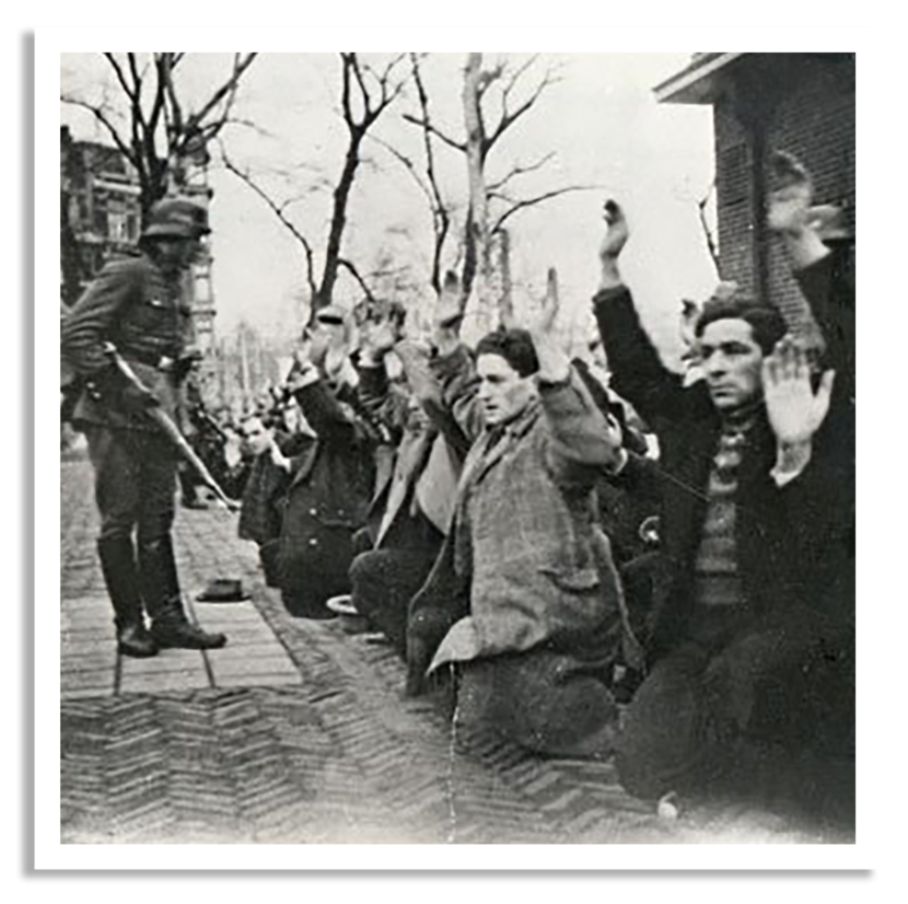 Een groep mensen knielt op straat met opgestoken handen, terwijl een gewapende soldaat toezicht houdt. De sfeer voelt bedreigend en onderdrukkend.