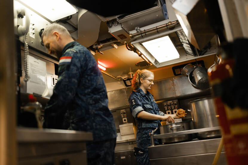 Matroos Myrthe en een collega staan in de kombuis te roeren in de pannen.
