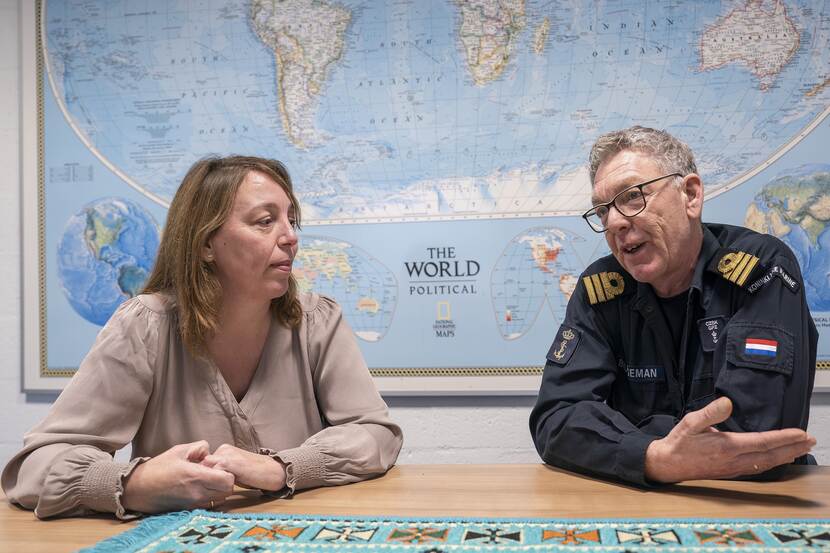 Simone Boekel en overste Cees Bruggeman samen achter een tafel met wereldkaart op de achtergrond