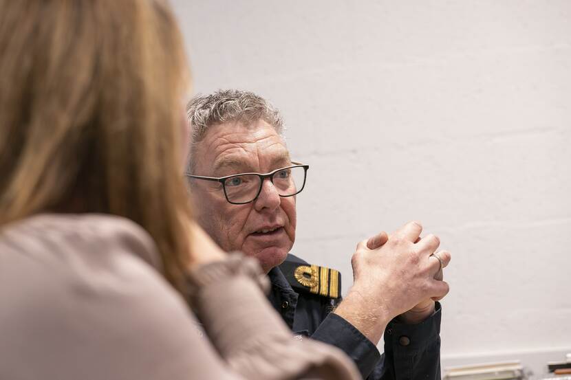Simone Boekel en overste Cees Bruggeman samen achter een tafel met wereldkaart op de achtergrond