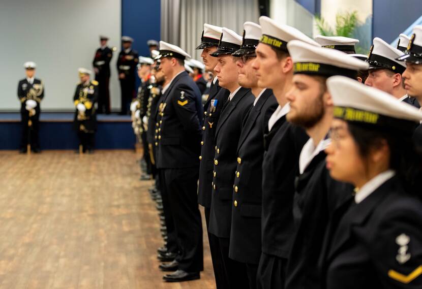 Een rij militairen staat in de houding.