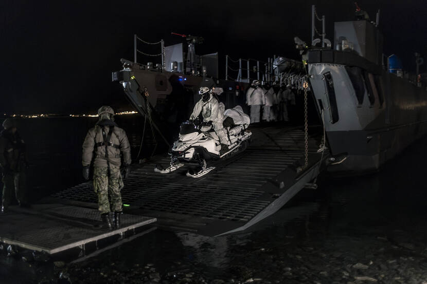 Een marinier op een sneeuwscooter voert een nachtelijke landing uit op een strand bij Alta in Noorwegen.