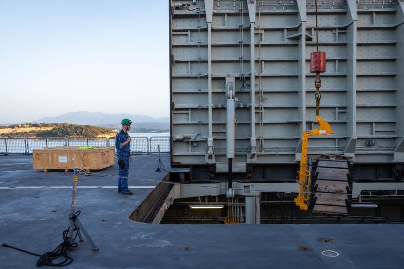een pallet wordt met een kraan in de Karel Doorman geladen.