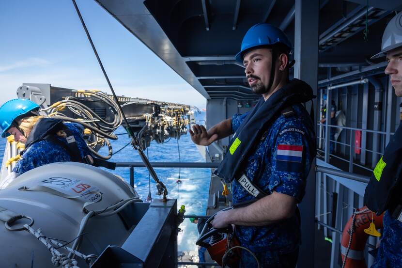 Marineman aan boord van de Doorman staat klaar voor bevoorrading op zee.