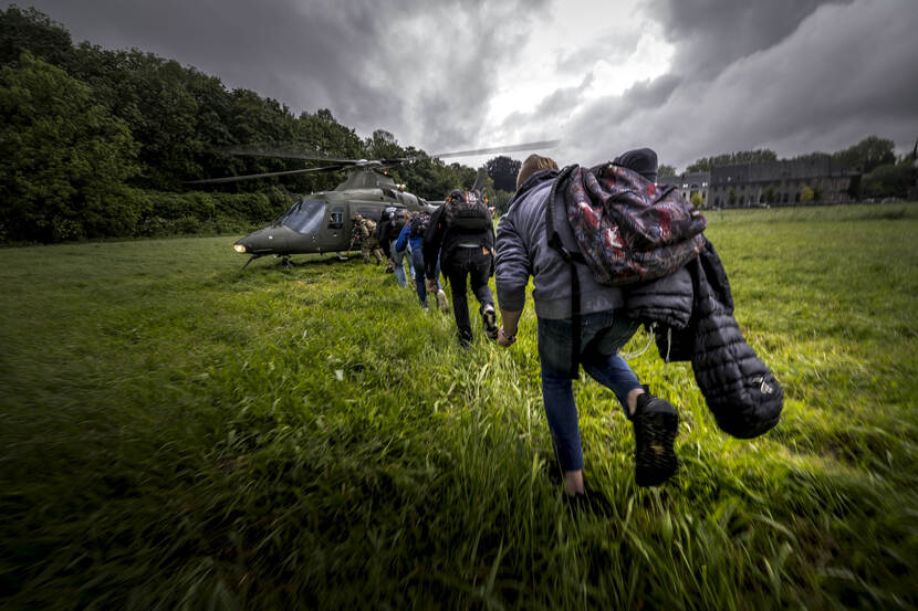 Terwijl de rotorbladen van de helikopter op volle toeren draaien, rennen jongeren richting de deur van hun voertuig.