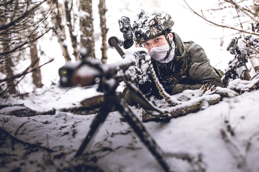 Een MAG-schutter liggend in de sneeuw.