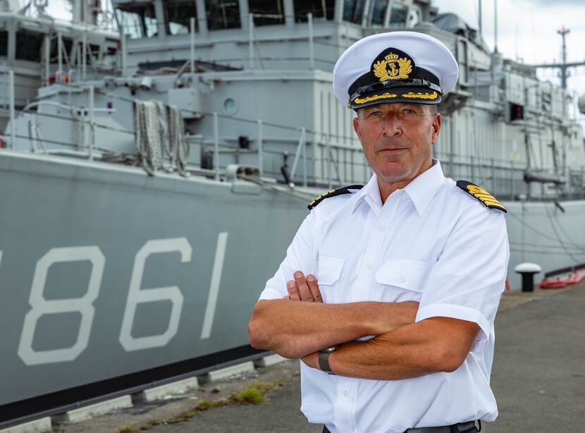 Kaptein ter zee Lex van der Kraan voor een schip in de haven van Den Helder.