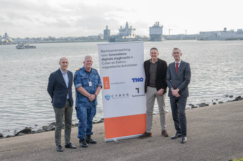 Het viertal dat het contract heeft ondertekend met een banner naast het bassin van de Nieuwe Haven.