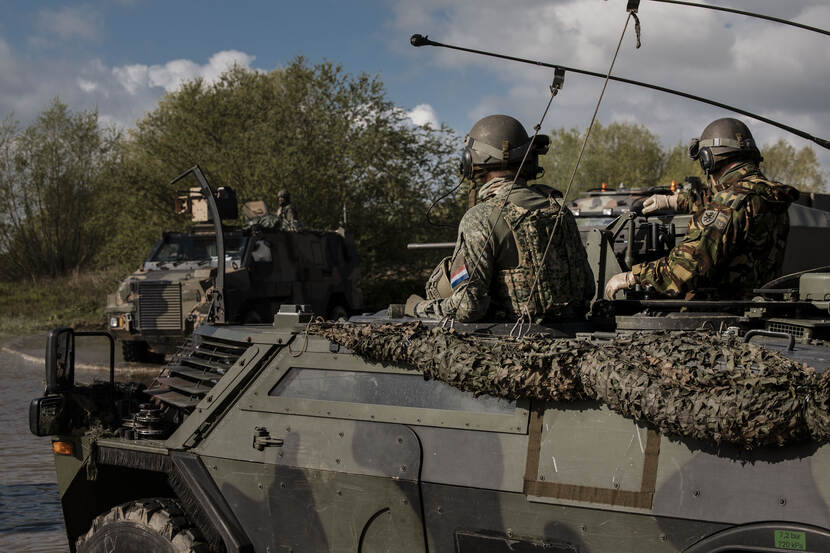 De voertuigen van 13 Lichte Brigade staan klaar om de brug over te gaan.