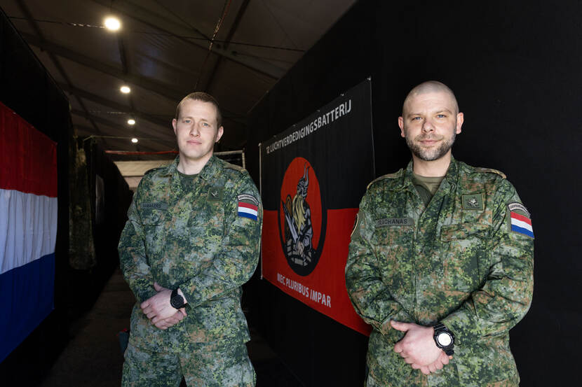 Majoor Jeroen en opperwachtmeester Trachanas poseren voor een vlag van 12 Luchtverdedigingsbatterij.