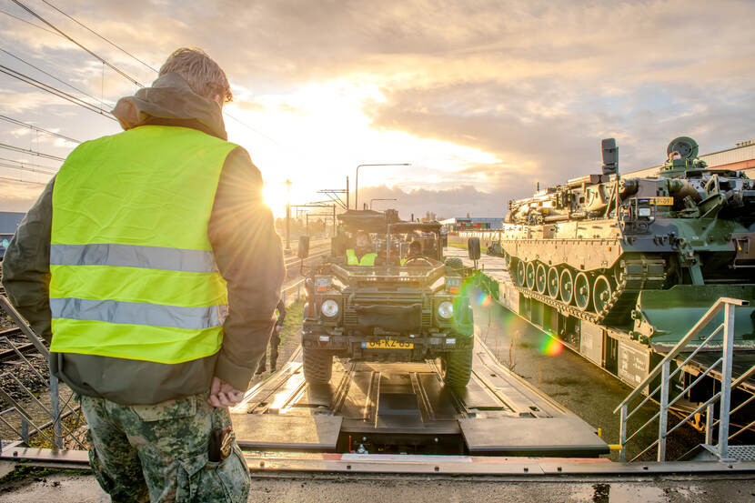 Een militair kijkt naar spoorrails.