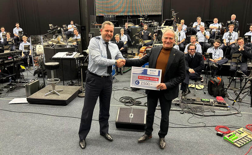 Orkestdirecteur majoor Toine Jongbloets reikt de cheque uit aan voorzitter commodore b.d. Jan van Hoof.