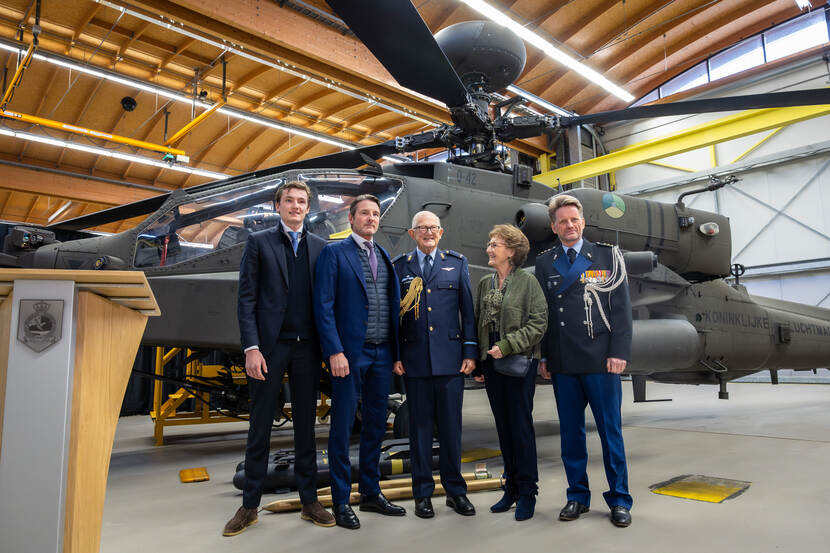 Prof. mr. Pieter van Vollenhoven en zijn familie poseren in een hangar voor een Apache.