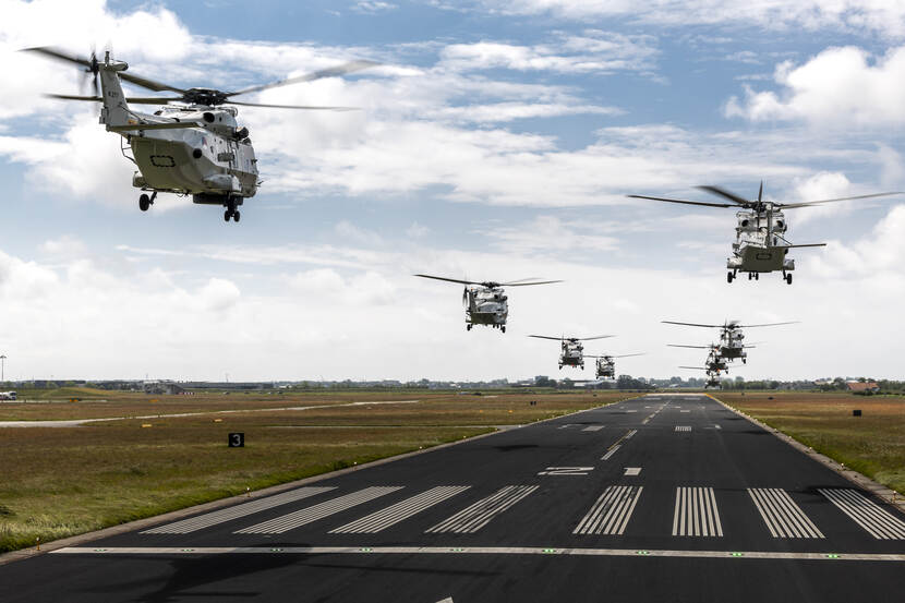 Acht NH90’s boven een startbaan.