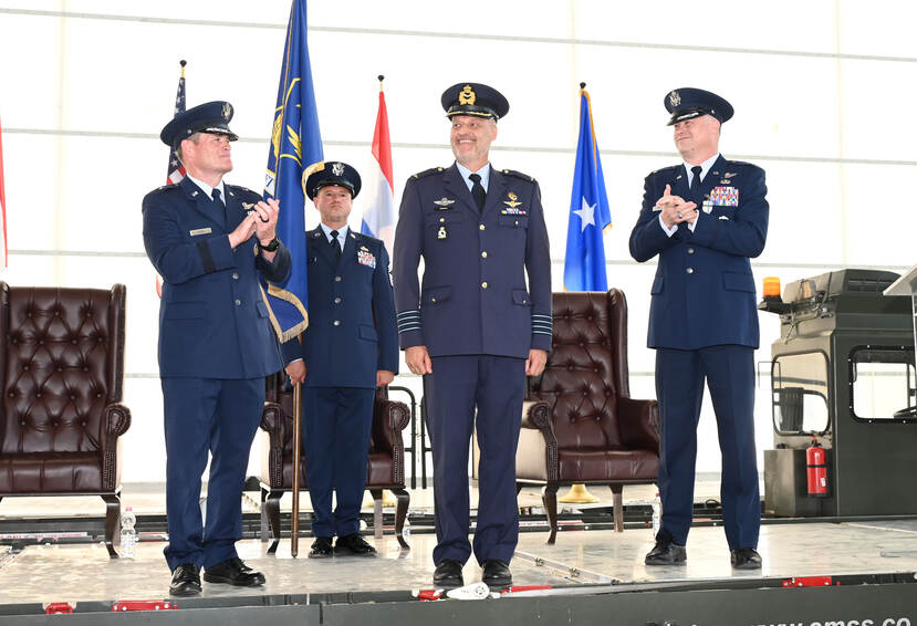 Oostema op een podium te midden van drie buitenlandse luchtmachtmilitairen.