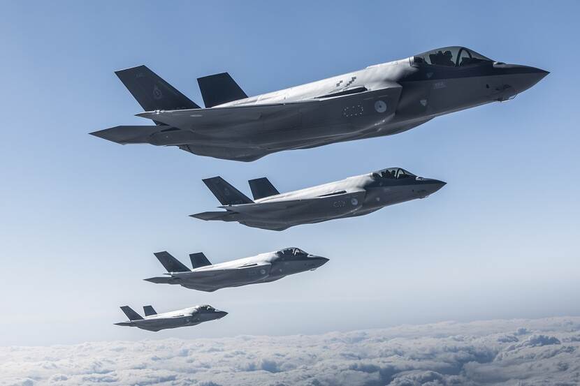 Vier F-35’s op rij boven een wolkendek.