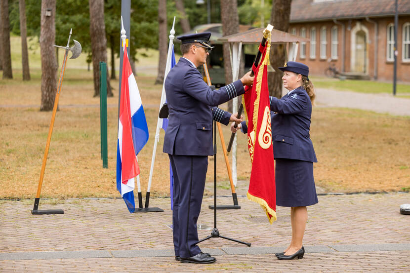 Kolonel Bibi Schmitz overhandigt de vlag aan kolonel Carlo Mekes.