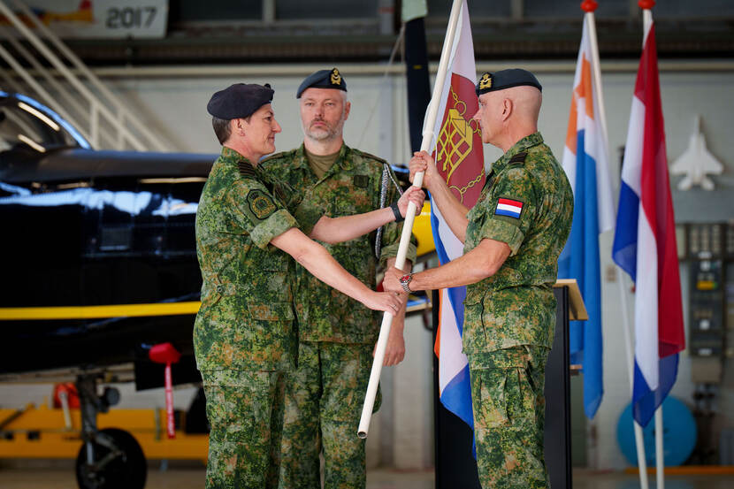 Steur overhandigt de vlag aan Verhulst.