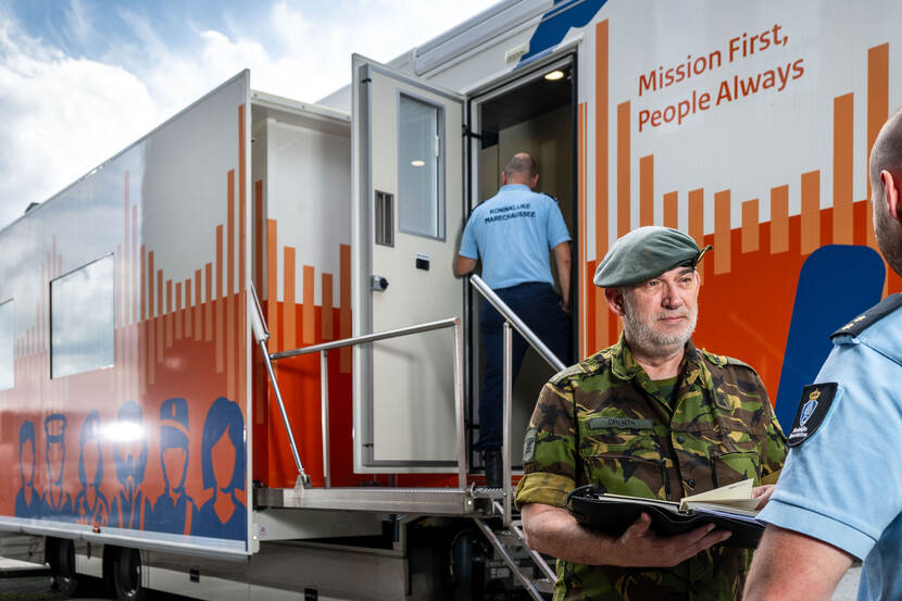 Marechaussee loopt de audiotrailer in.