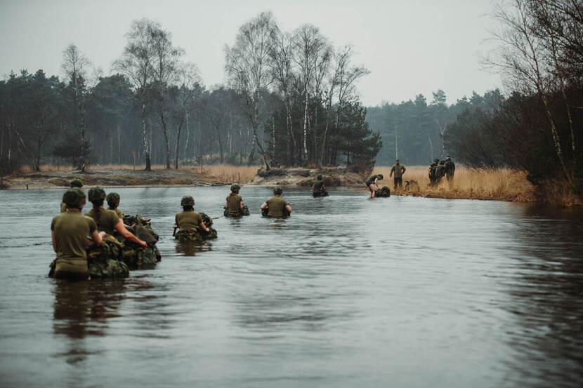 Collega's maken een oversteek door het water.