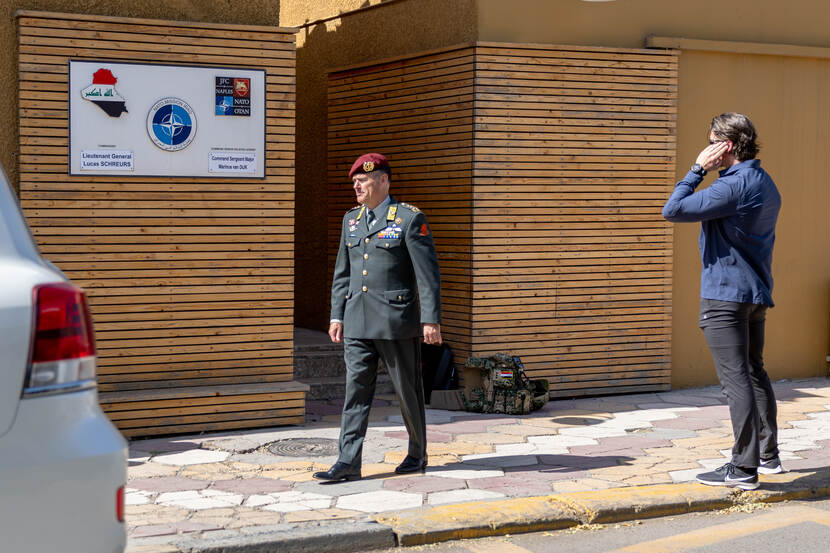 Generaal Cas Schreurs loopt naar een voertuig. Daarnaast praat een onherkenbare BSB’er in een oortje.