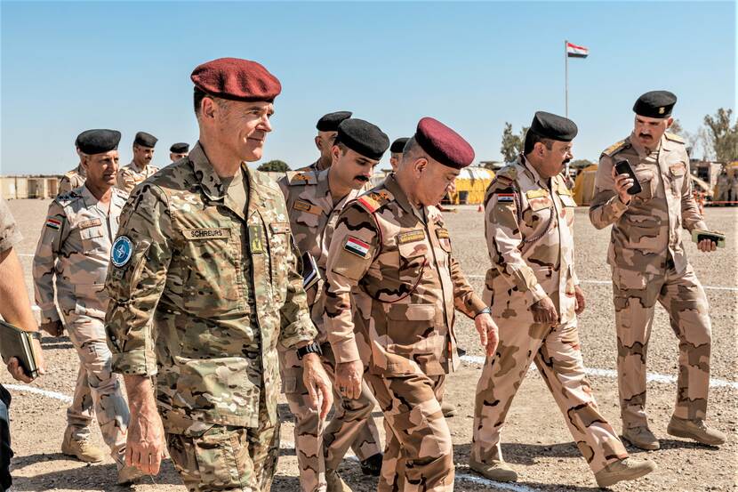 Generaal Cas Schreurs loopt door Irak. Achter hem lopen militaire collega’s uit andere landen.