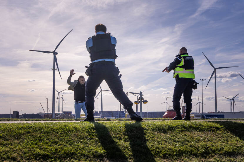 Medewerkers van de marechaussee houden een arrestant onder schot.