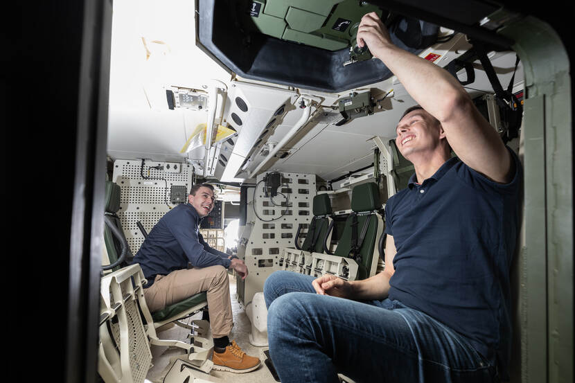 Stagiair Etiën Tax en begeleider Erik van Uem bekijken het interieur van een Boxer pantservoertuig.