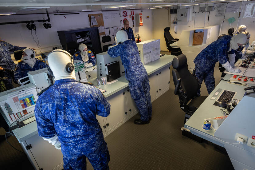 Militairen dragen anti flash gear en hebben over in de technische centrale tijdens een calamiteit.