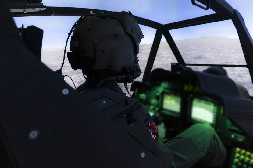 Apache-vlieger in simulator oefent in virtuele wereld een missie.