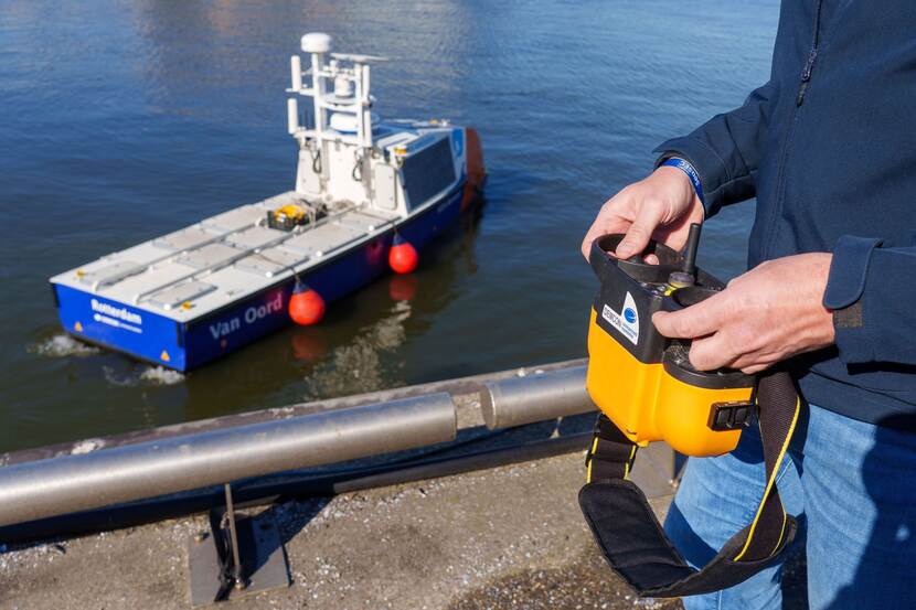 een man bestuurt vanaf de kade een onbemand vaartuig