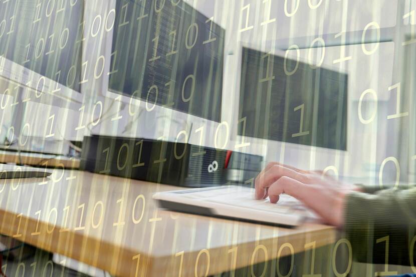 Een hand typt iets op een toetsenbord