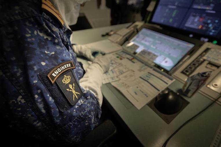 Een marineofficier werkt achter een computerscherm