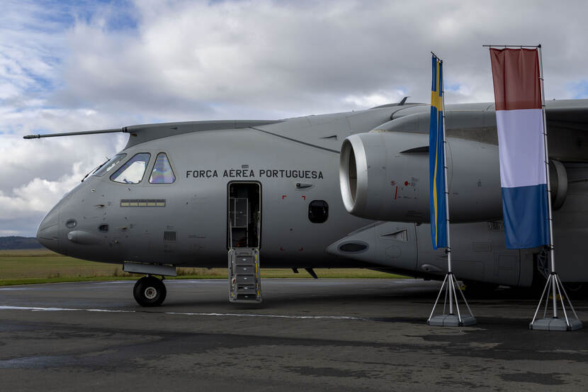 De grijze C-390. Voor dit grote vliegtuig, waarvan de helft zichtbaar is, staan Zweedse en Nederlandse vlaggen.