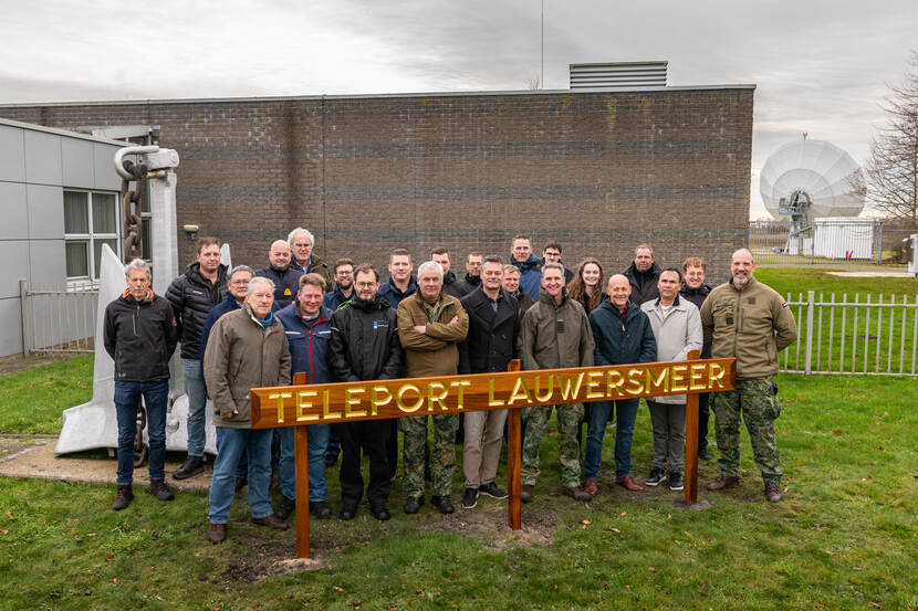 Een groep mensen voor het nieuwe teleport-bord in Zoutkamp