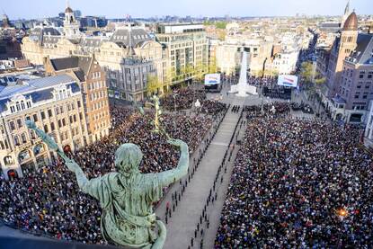 Luchtfoto van een enorme menigte op de Dam tijdens de Nationale Dodenherdenking.