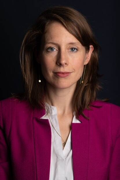 Portret van vrouw met bruin haar, witte blouse en paars jasje