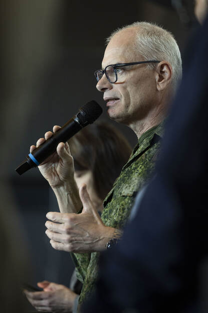 Portret van generaal Van der Touw met microfoon in zijn hand.