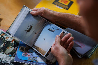 Een portretfoto van Arthur waarbij hij door oude fotoboeken bladert.