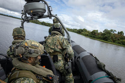 Links een Colombiaanse Piranha-onderscheppingsboot in volle vaart. Rechts een Nederlandse FRISC-onderscheppingsboot op een  rivier.