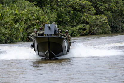 Links een Colombiaanse Piranha-onderscheppingsboot in volle vaart. Rechts een Nederlandse FRISC-onderscheppingsboot op een  rivier.